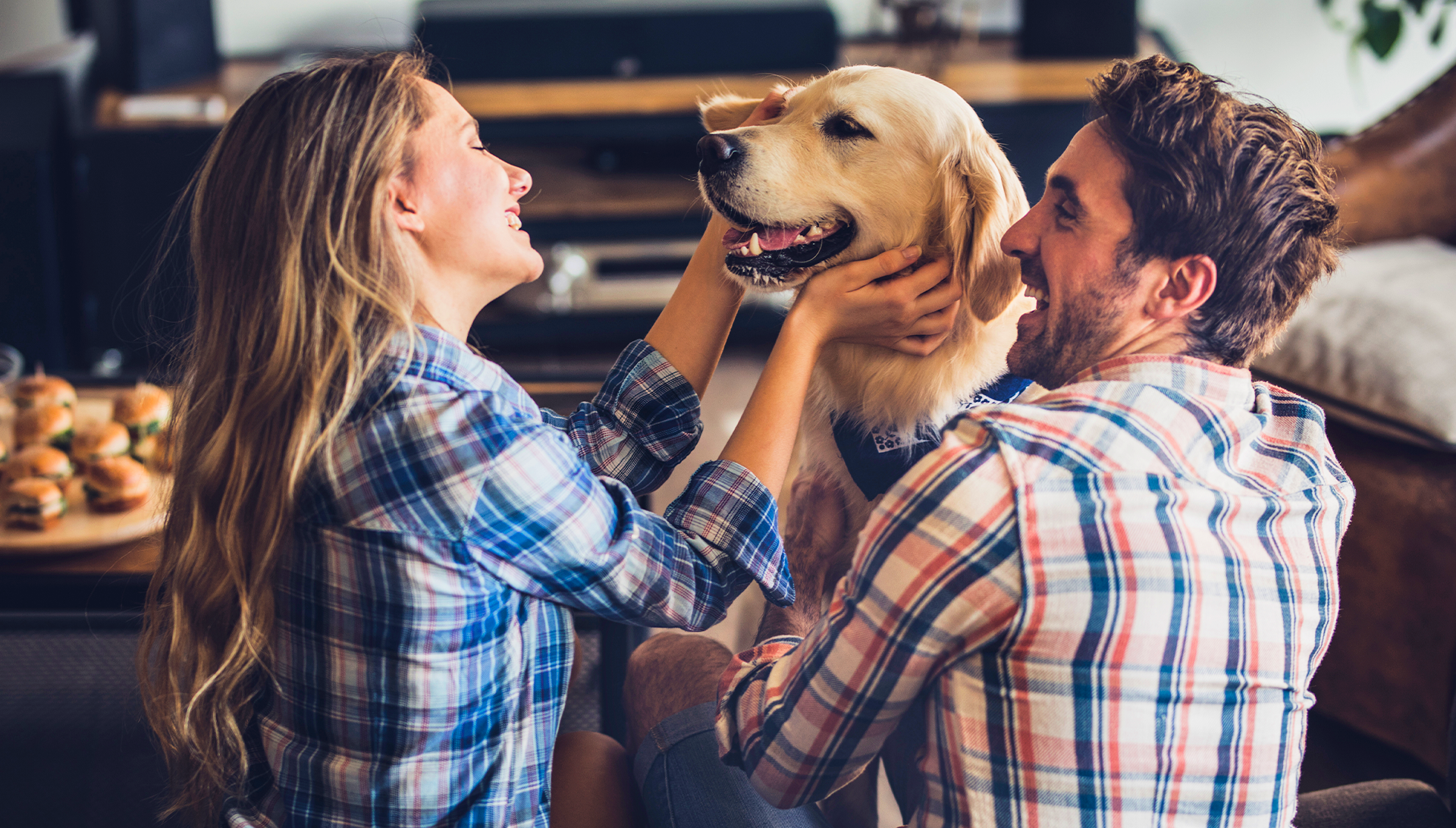 Pareja-feliz-acariciando-a-su-perro